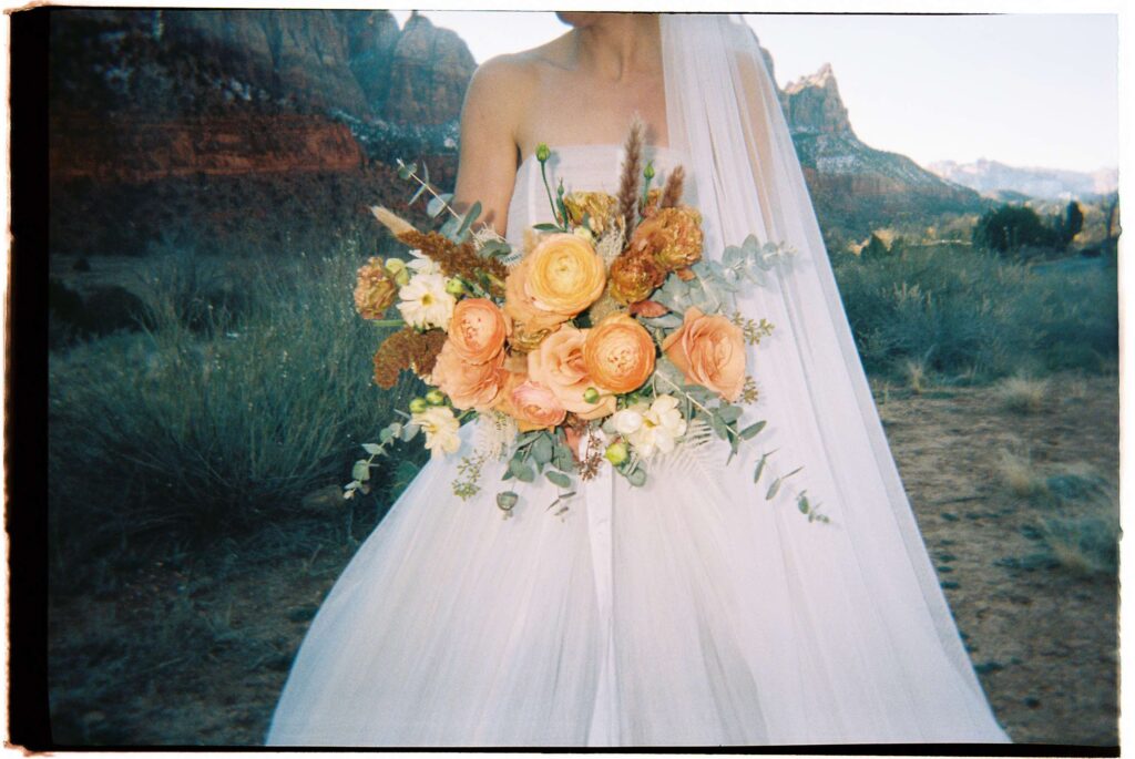 Film wedding photo of a bride holding a bouquet of flowers in Zion National Park, Utah.