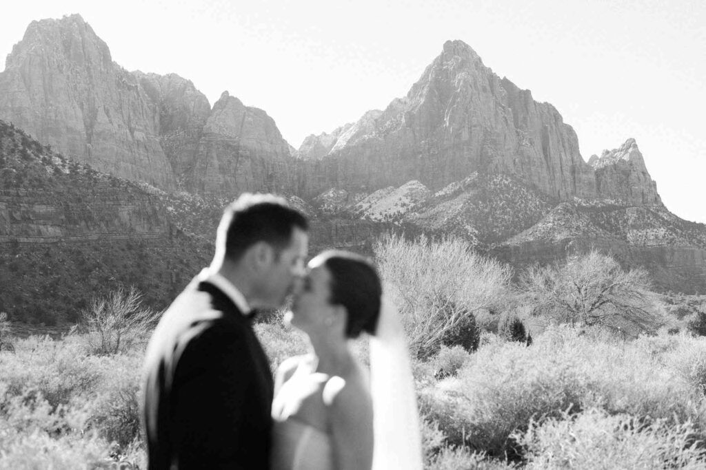 Bride and groom surrounded by red rocks in Zion National Park.