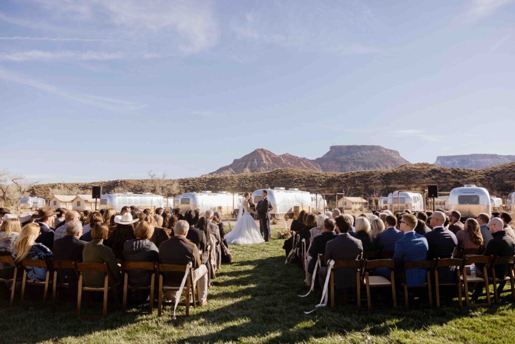 Wedding ceremony photo of a bride and groom exchanging vows at AutoCamp Zion in Utah near Zion National Park.