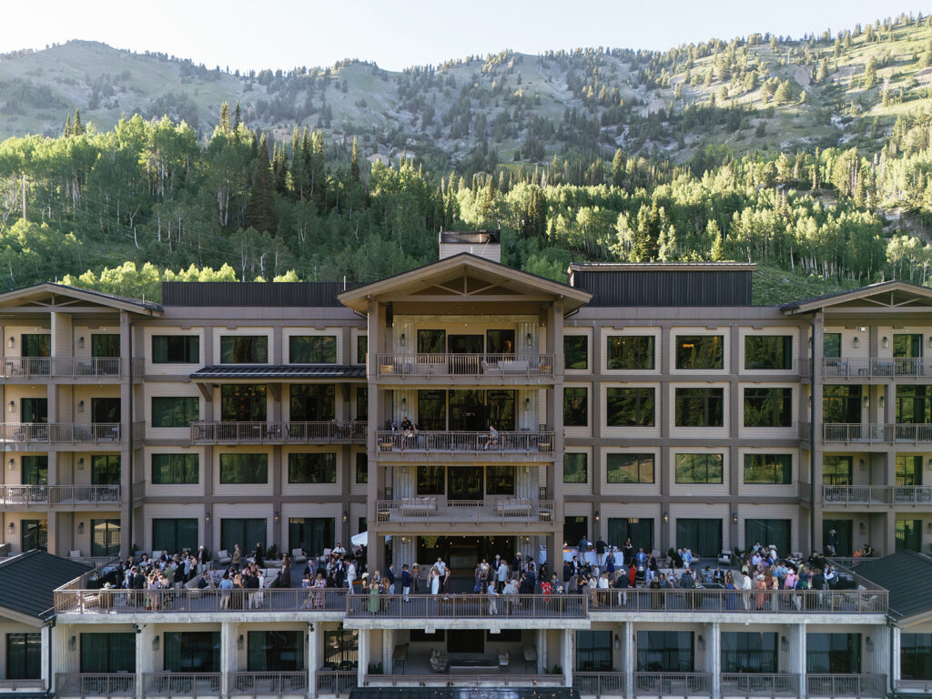Guests enjoying an outdoor wedding cocktail hour on the terrace at Snowpine Lodge in Little Cottonwood Canyon, Utah.