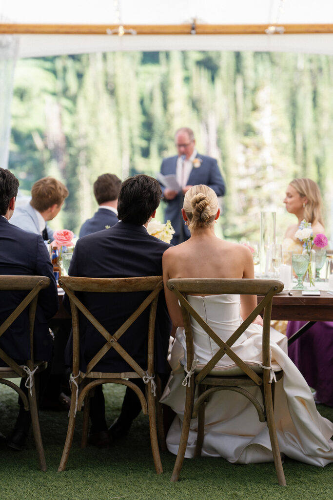 Bride and groom listening to a heartfelt speech during their wedding reception at Snowpine Lodge in Little Cottonwood Canyon, Utah.